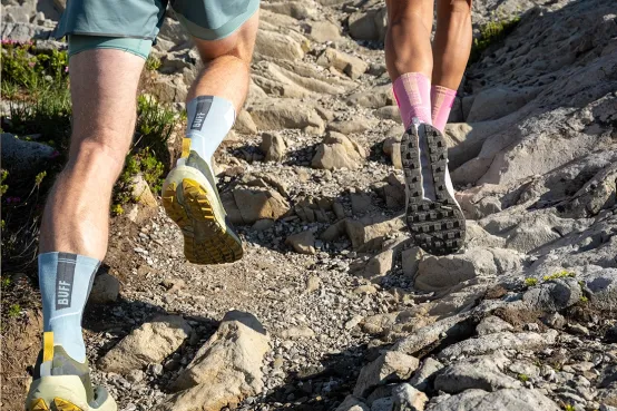 Hikers wearing BUFF performance socks with HeiQ Mint odour control and HeiQ Smart Temp adaptive cooling technology on a rocky mountain trail